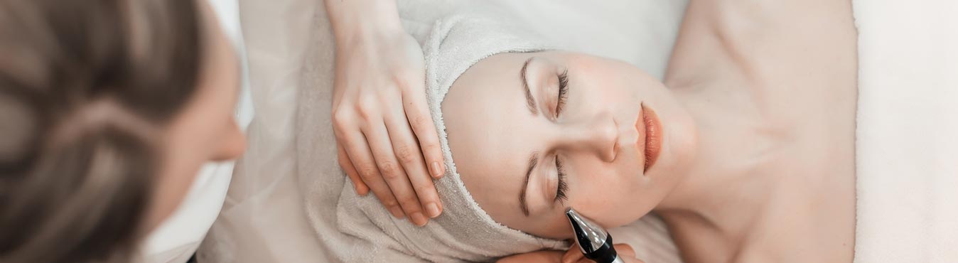 Women laying down with a towel wrapped around her head in a spa like environment